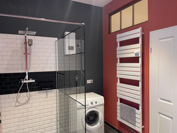 Badezimmer mit Dusche, Washmaschine und Handtuch-Heizkörper Moderne Badezimmer mit Dusche, Waschmaschine und Handtuchheizkörper.