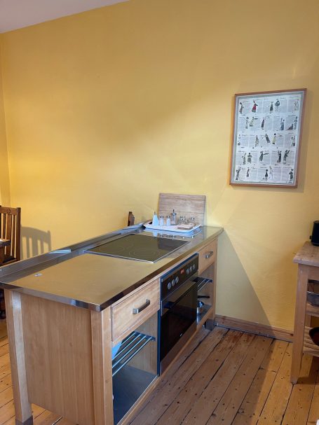 Kochinsel in der Küche Moderne Küche mit gelben Wänden, Holzschränken und Kochfeld.