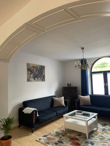 Wohnzimmer Wohnzimmer mit Couchgarnitur, Couchtisch, Fenster und Kunstwerk an der Wand.